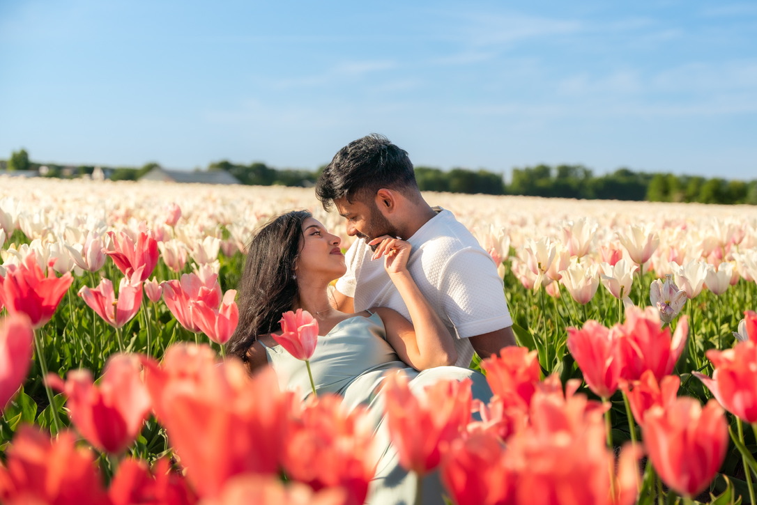 Shajeethan and Sheffinea sitting together among colourful tulips